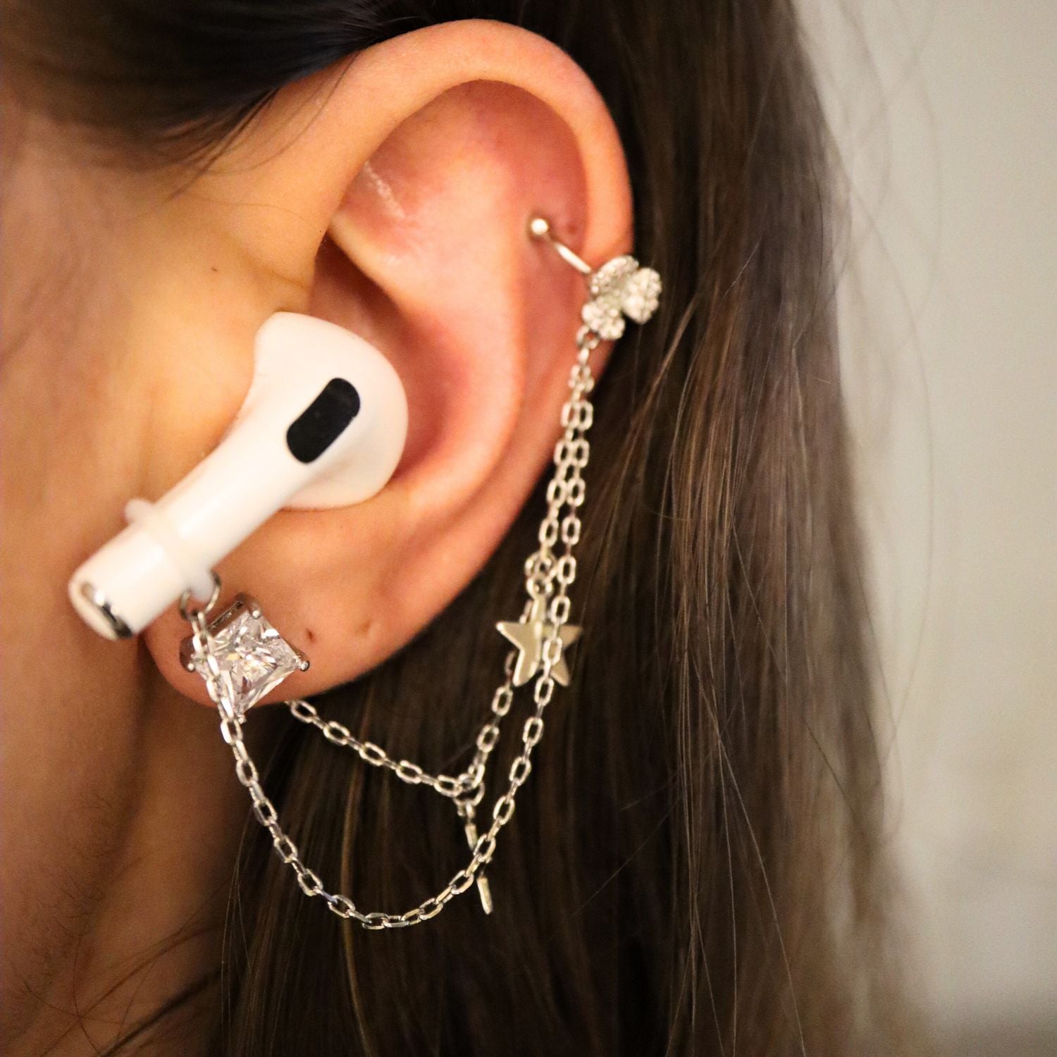 Earcuffs Oorbellen Voor Oordopjes (Ster) Zilverkleurig op model met Airpods